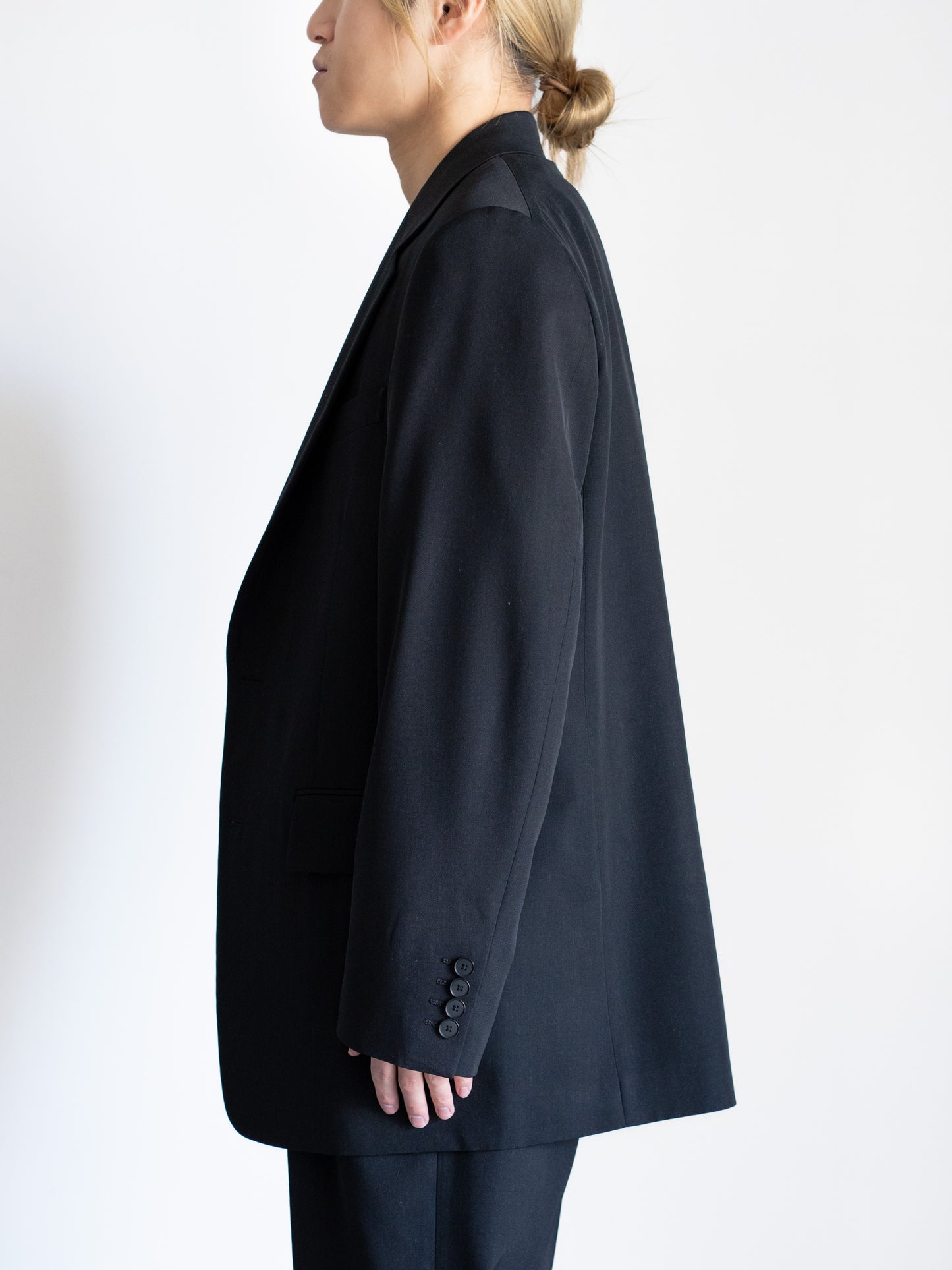 AURLEEのLIGHT WOOL MAX GABARDINE JACKETのカラーがBLACKを着用したトップスが写った横からの着用画像です。