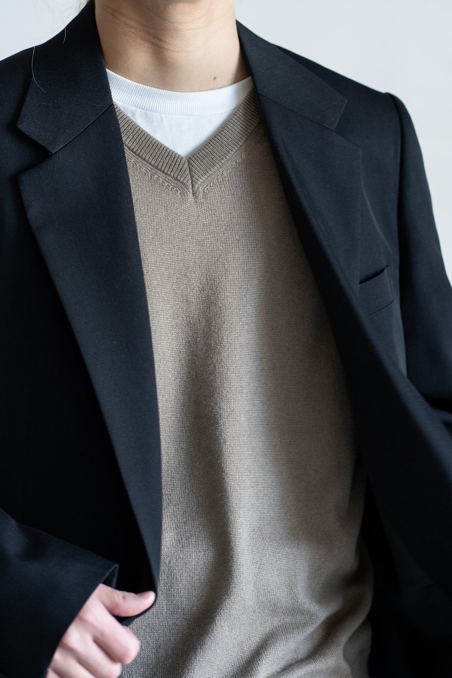 AURLEEのLIGHT WOOL MAX GABARDINE JACKETのカラーがBLACKを着用した襟元に寄った着用画像です。