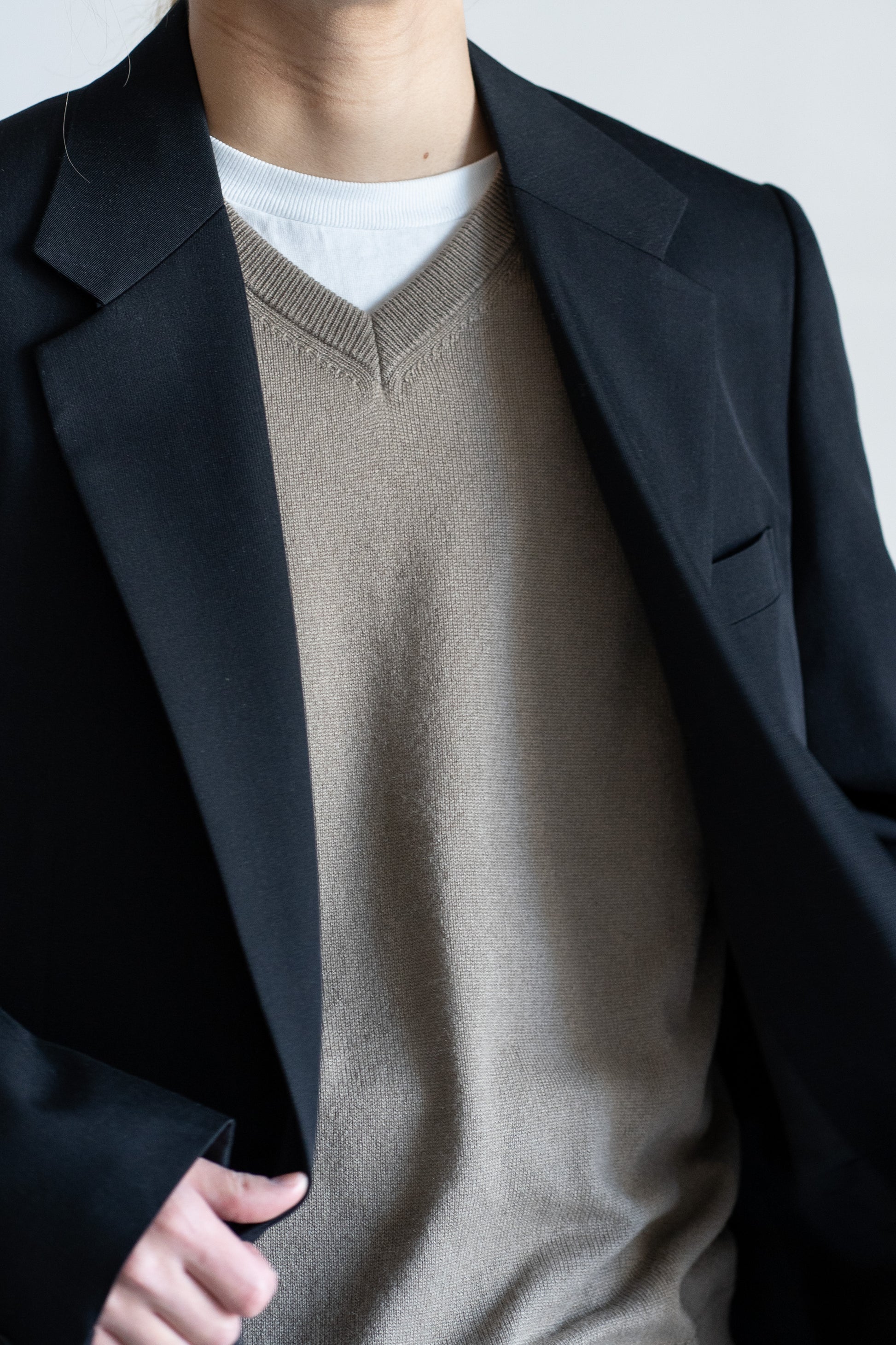 AURLEEのLIGHT WOOL MAX GABARDINE JACKETのカラーがBLACKを着用した襟元に寄った着用画像です。