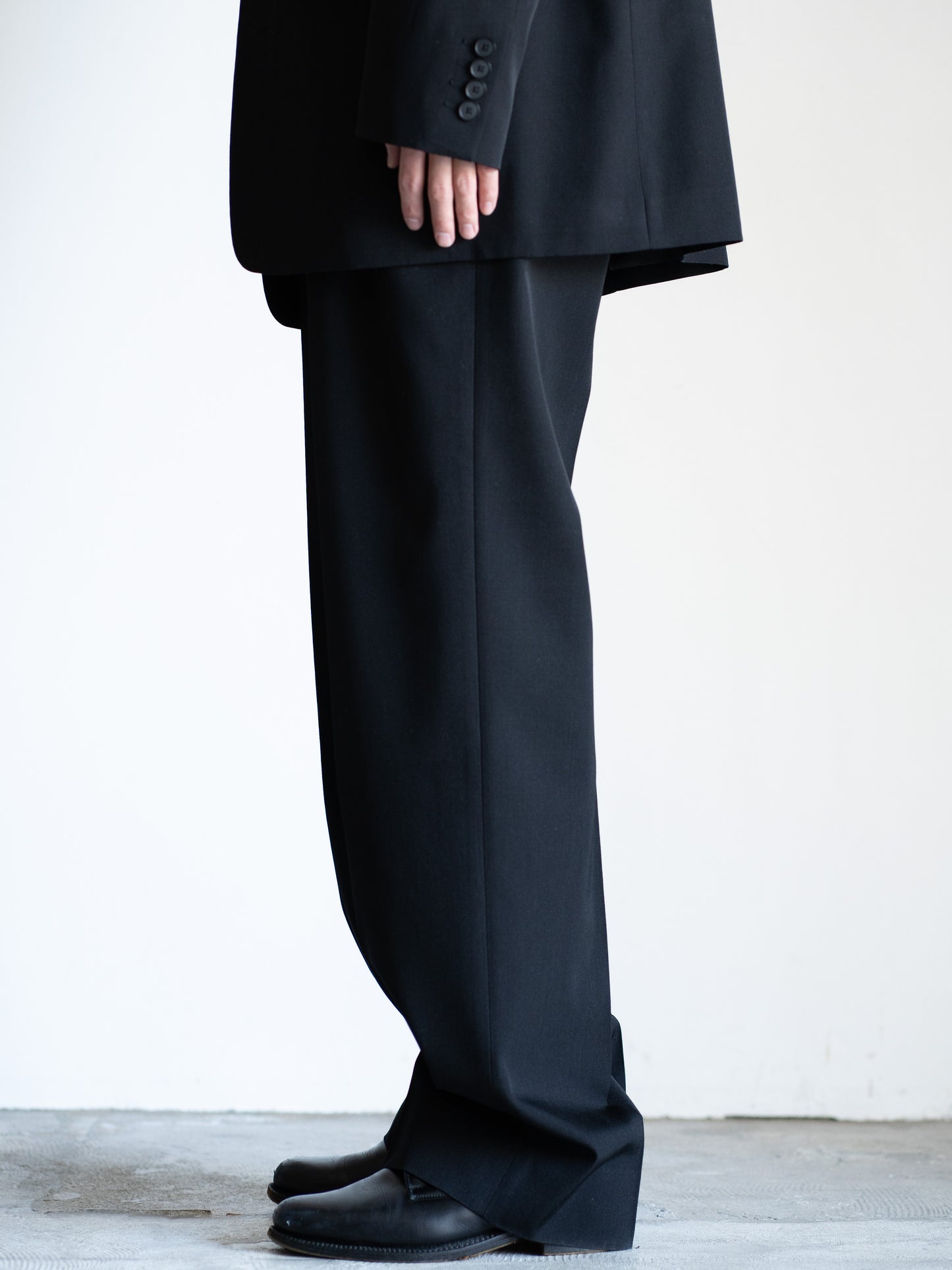 AURALEEのLIGHT WOOL MAX GABARDINE TWO-TUCK SLACKSのカラーはブラックの横から見た着用画像です。