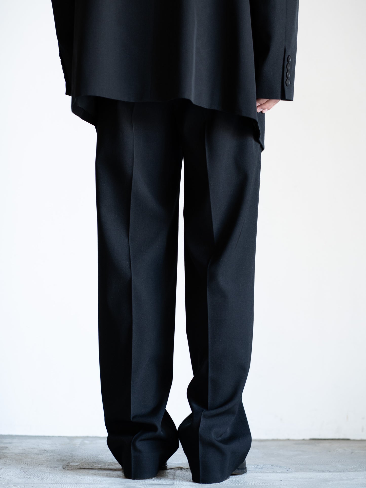 AURALEEのLIGHT WOOL MAX GABARDINE TWO-TUCK SLACKSのカラーはブラックの背面から見た着用画像です。