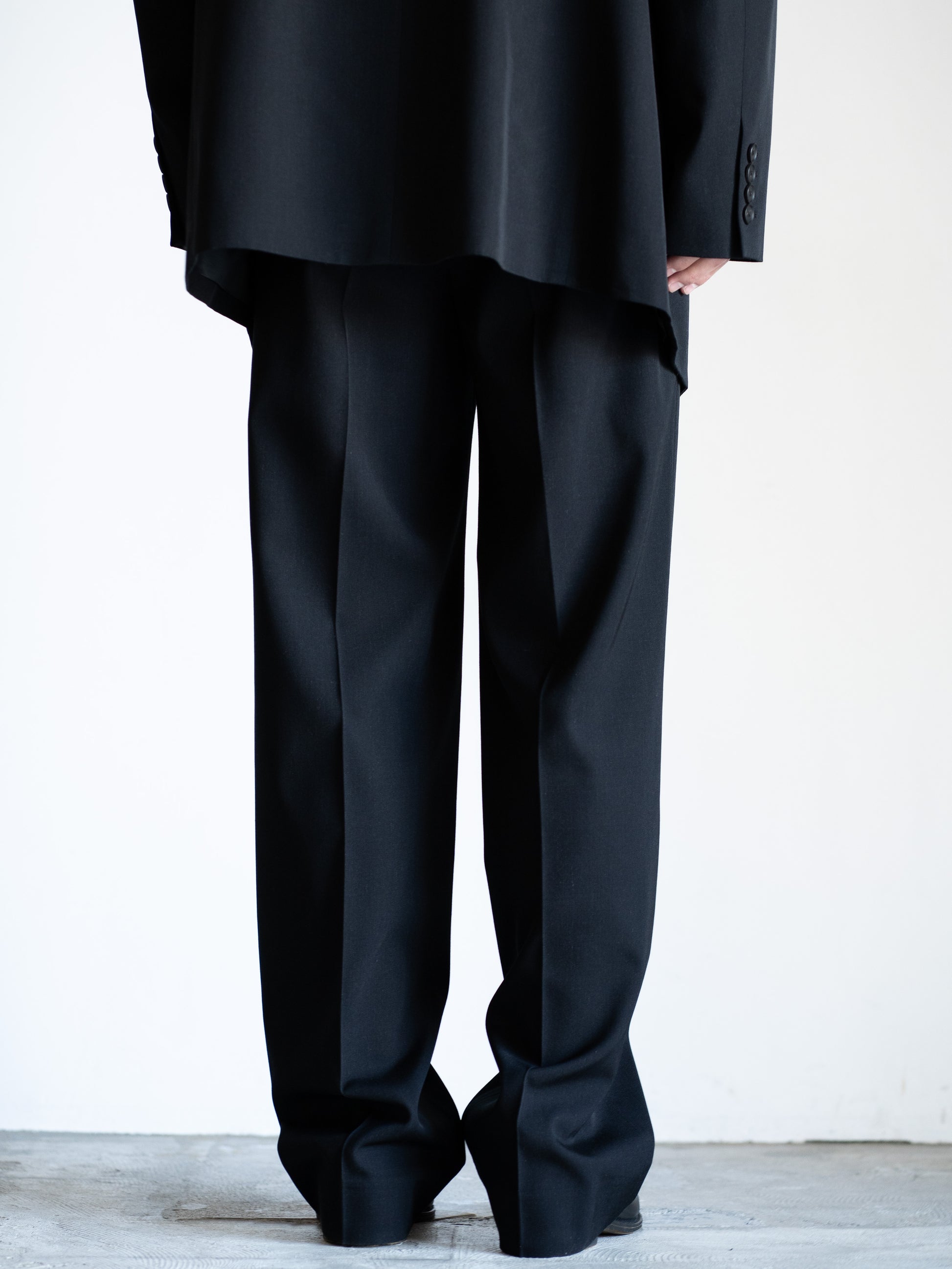 AURALEEのLIGHT WOOL MAX GABARDINE TWO-TUCK SLACKSのカラーはブラックの背面から見た着用画像です。