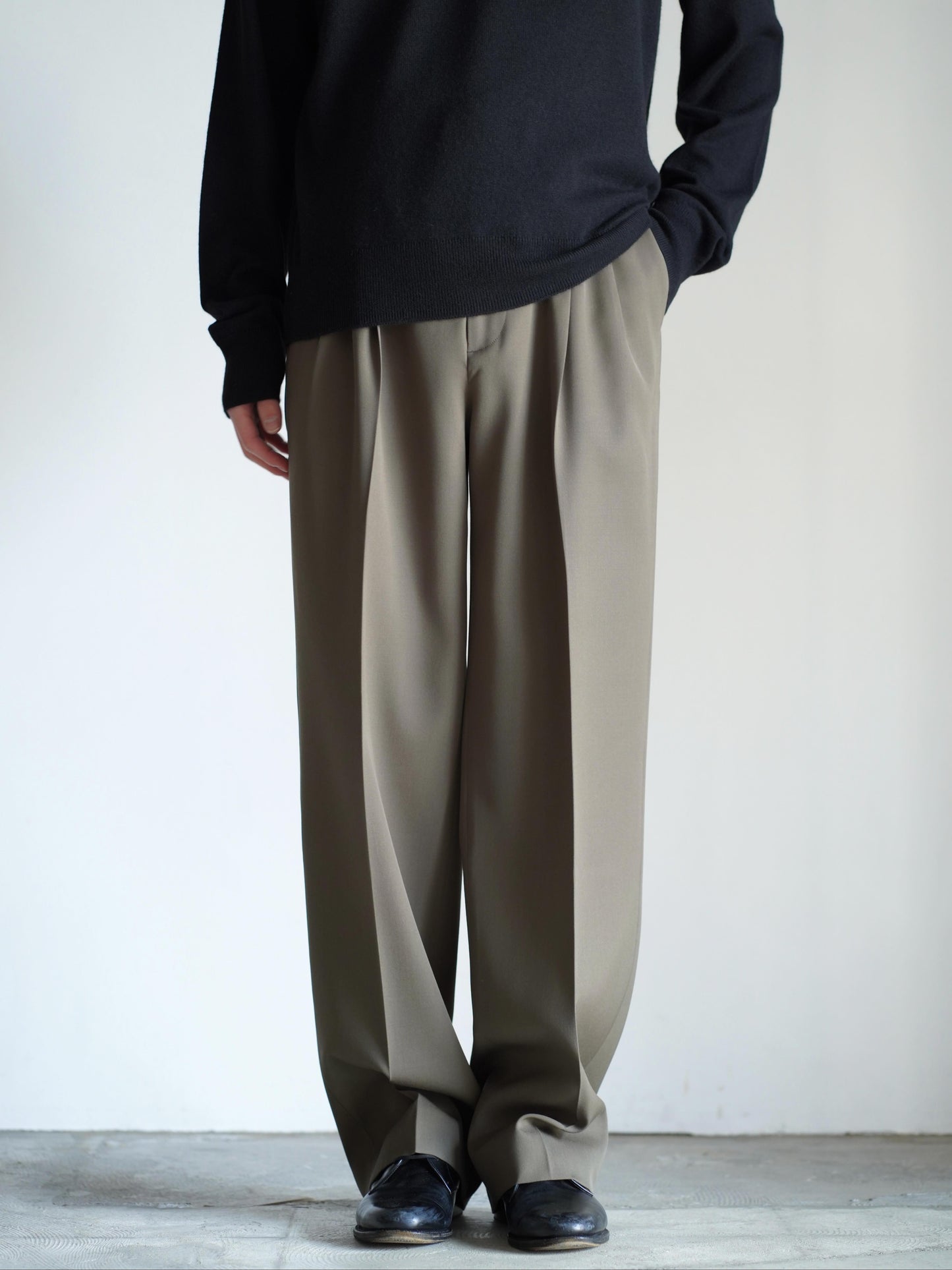 AURALEEのLIGHT WOOL MAX GABARDINE TWO-TUCK SLACKSのカラーはダークオリーブブラウンの正面から見た着用画像です。
こちらの商品は通信販売で購入可能です。