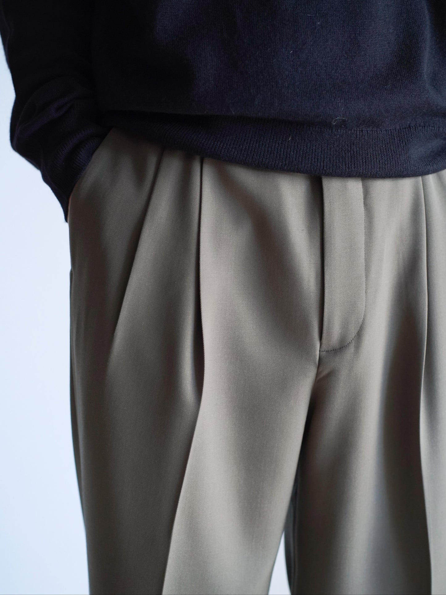 AURALEEのLIGHT WOOL MAX GABARDINE TWO-TUCK SLACKSのカラーはダークオリーブブラウンの腰元に寄って撮影した着用画像です。