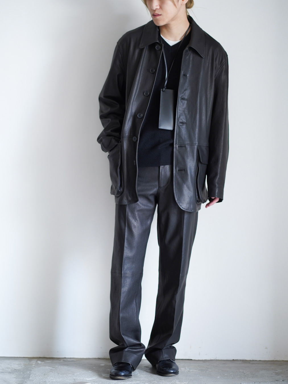 AURALEEのTEXTURED LAMB LEATHER BLOUSONとTEXTURED LAMB LEATHER PANTSのブルゾンのボタンを開けて着用した全体の写った正面の着用画像です。