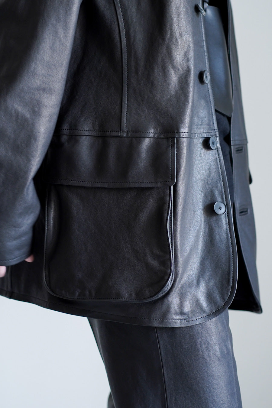 AURALEEのTEXTURED LAMB LEATHER BLOUSONのフラップポケットに寄った着用画像です。