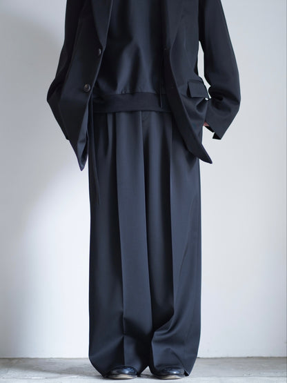 sssteinのLONG WIDE TROUSERSのカラーはBLACKのパンツの正面が写る着用画像です。こちらの商品は通信販売で購入可能です。
