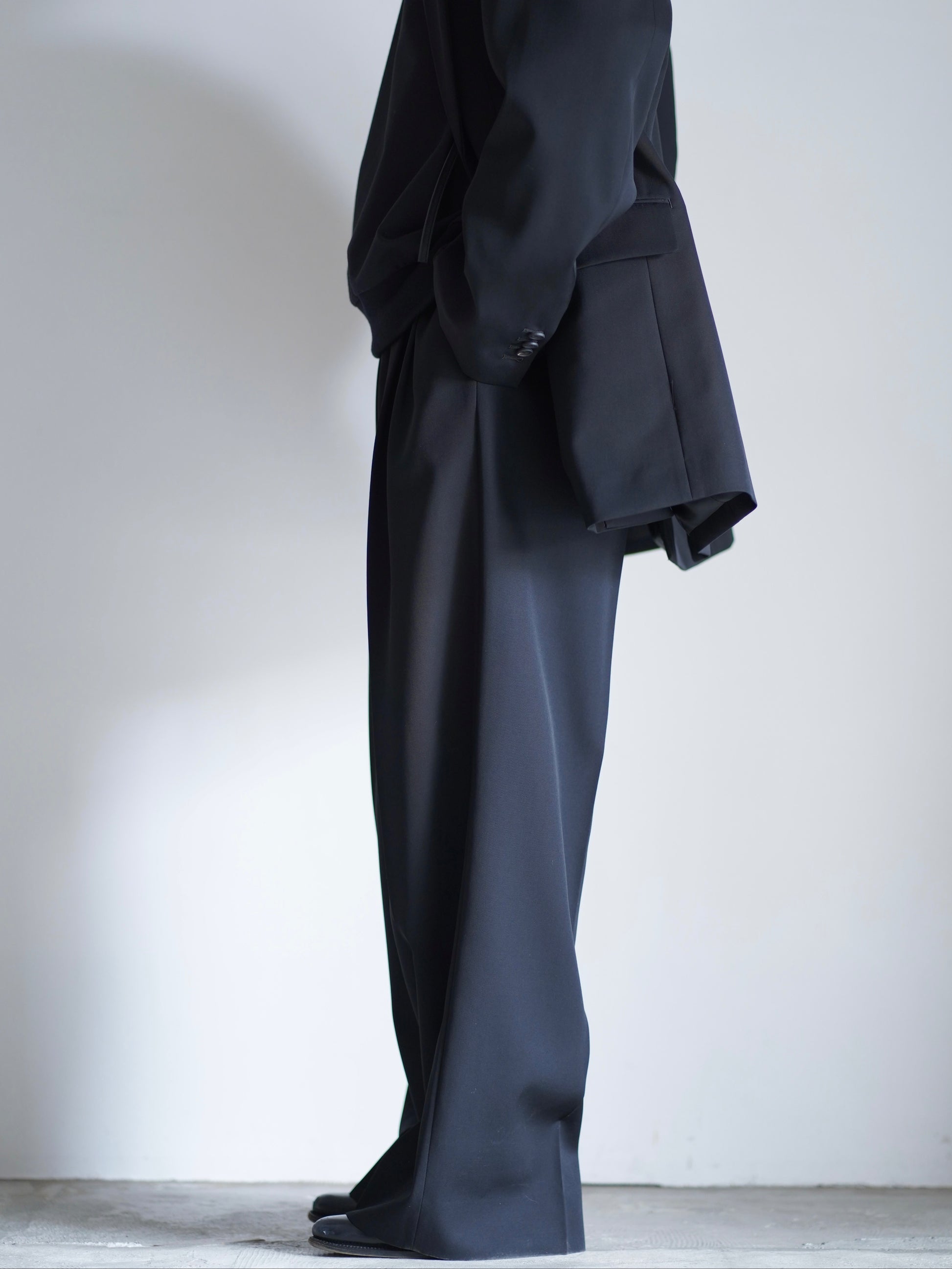 sssteinのLONG WIDE TROUSERSのカラーはBLACKのパンツの横向きの着用画像です。こちらの商品は通信販売で購入可能です。