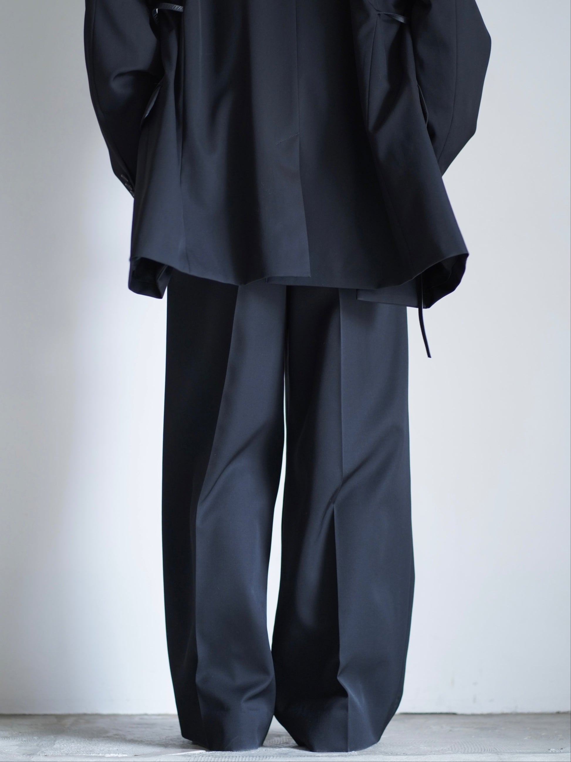 sssteinのLONG WIDE TROUSERSのカラーはBLACKのパンツの後向き着用画像です。こちらの商品は通信販売で購入可能です。