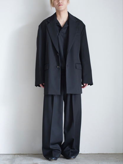sssteinのOVERSIZED SINGLE BREASTED LONG JACKETのカラーはBLACKのボタンを外して着用した際の全身が写った着用画像です。こちらの商品は通販での購入が可能です。