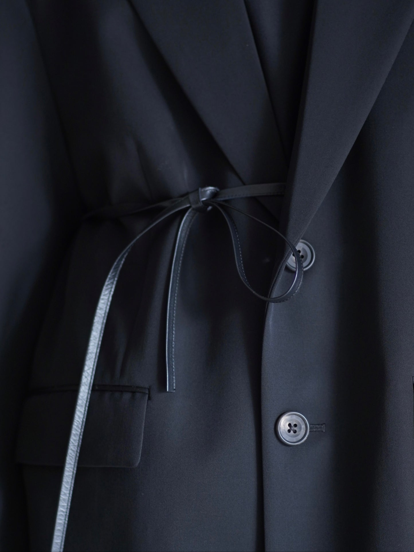 sssteinのOVERSIZED SINGLE BREASTED LONG JACKETのカラーはBLACKのレザーコードを結んだ際のレザーコードの画像です。こちらの商品は通販での購入が可能です。