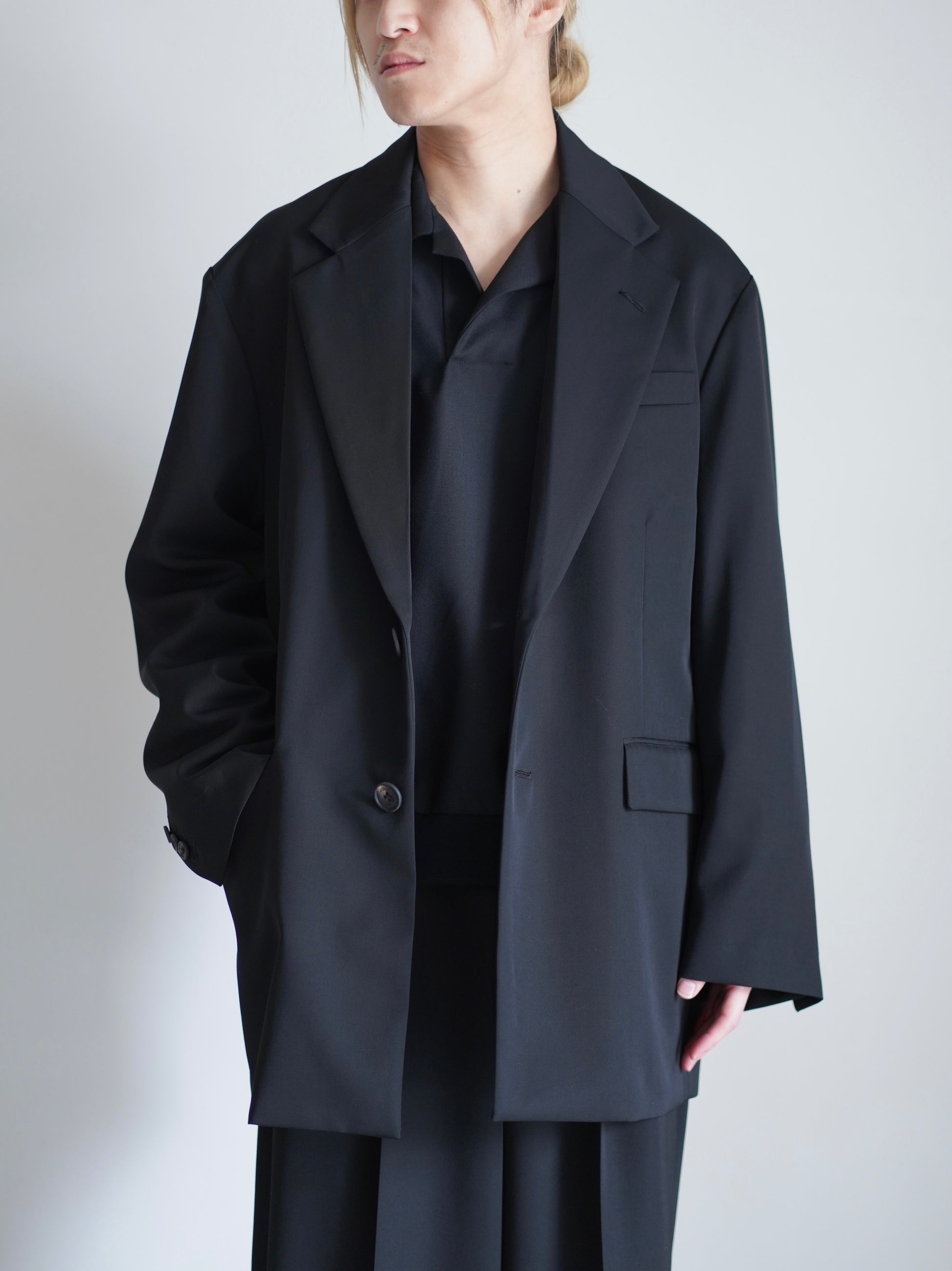 sssteinのOVERSIZED SINGLE BREASTED LONG JACKETのカラーはBLACKのボタンを外して着ているトップスの着用画像です。こちらの商品は通販での購入が可能です。