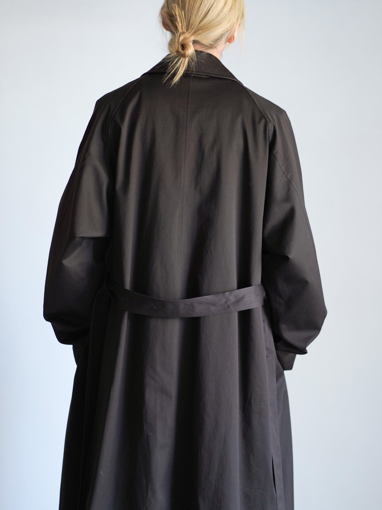 sssteinのOVERSIZED LAYERED COMBINATION COATのからーはDARK BROWNの上半身で後ろ向きの着用画像です。こちらは通販で購入可能です。