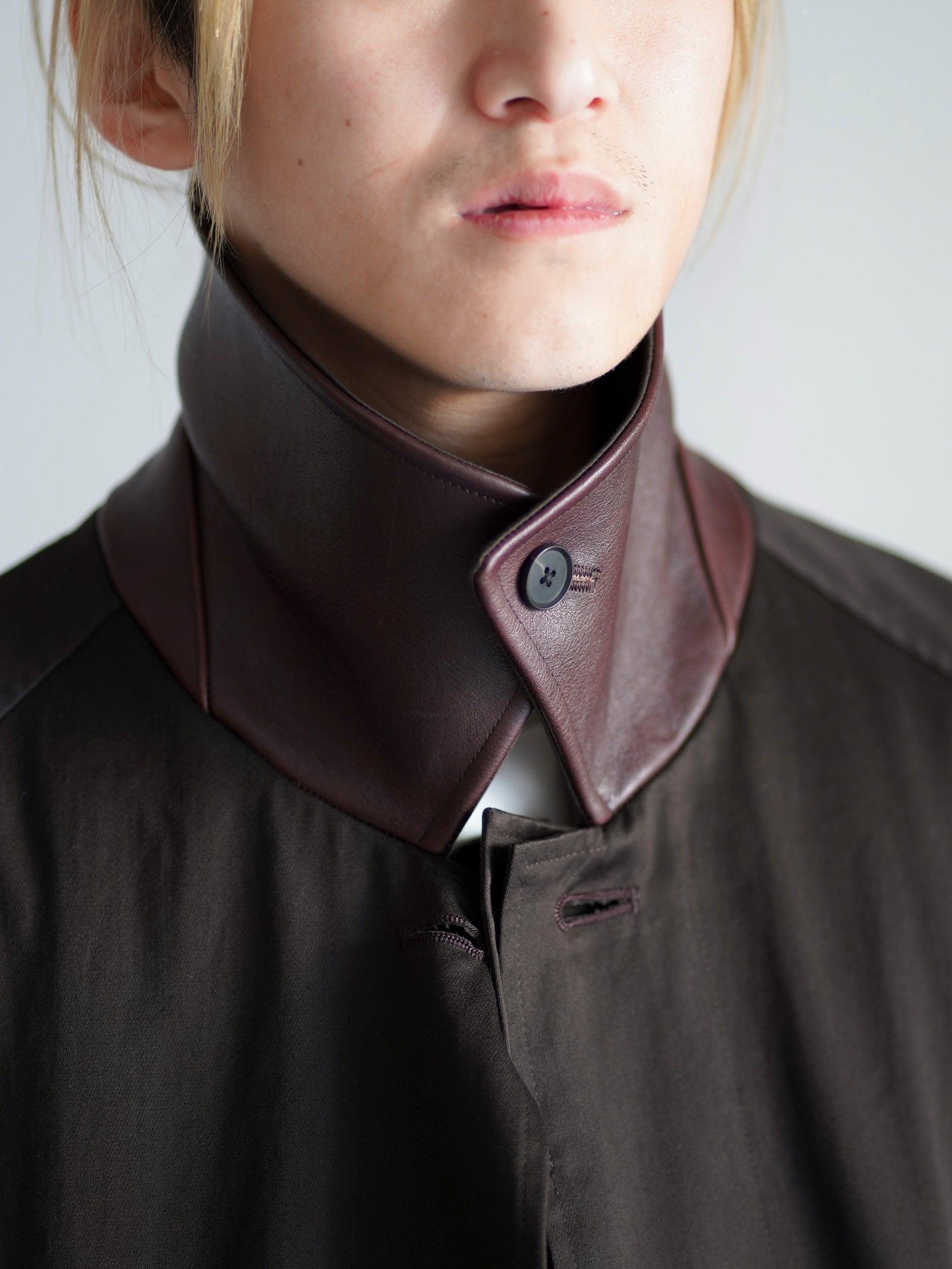 sssteinのOVERSIZED LAYERED COMBINATION COATのからーはDARK BROWNの襟を立ててアップにした画像です。こちらは通販で購入可能です。