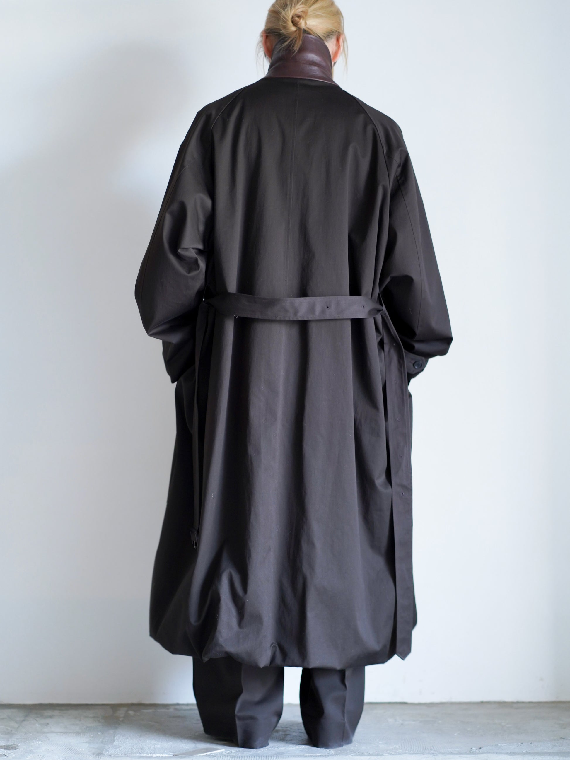 sssteinのOVERSIZED LAYERED COMBINATION COATのからーはDARK BROWNの後ろ向きの全身が写った着用画像です。こちらは通販で購入可能です。