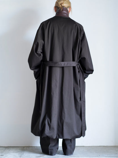 sssteinのOVERSIZED LAYERED COMBINATION COATのからーはDARK BROWNの後ろ向きの全身が写った着用画像です。こちらは通販で購入可能です。