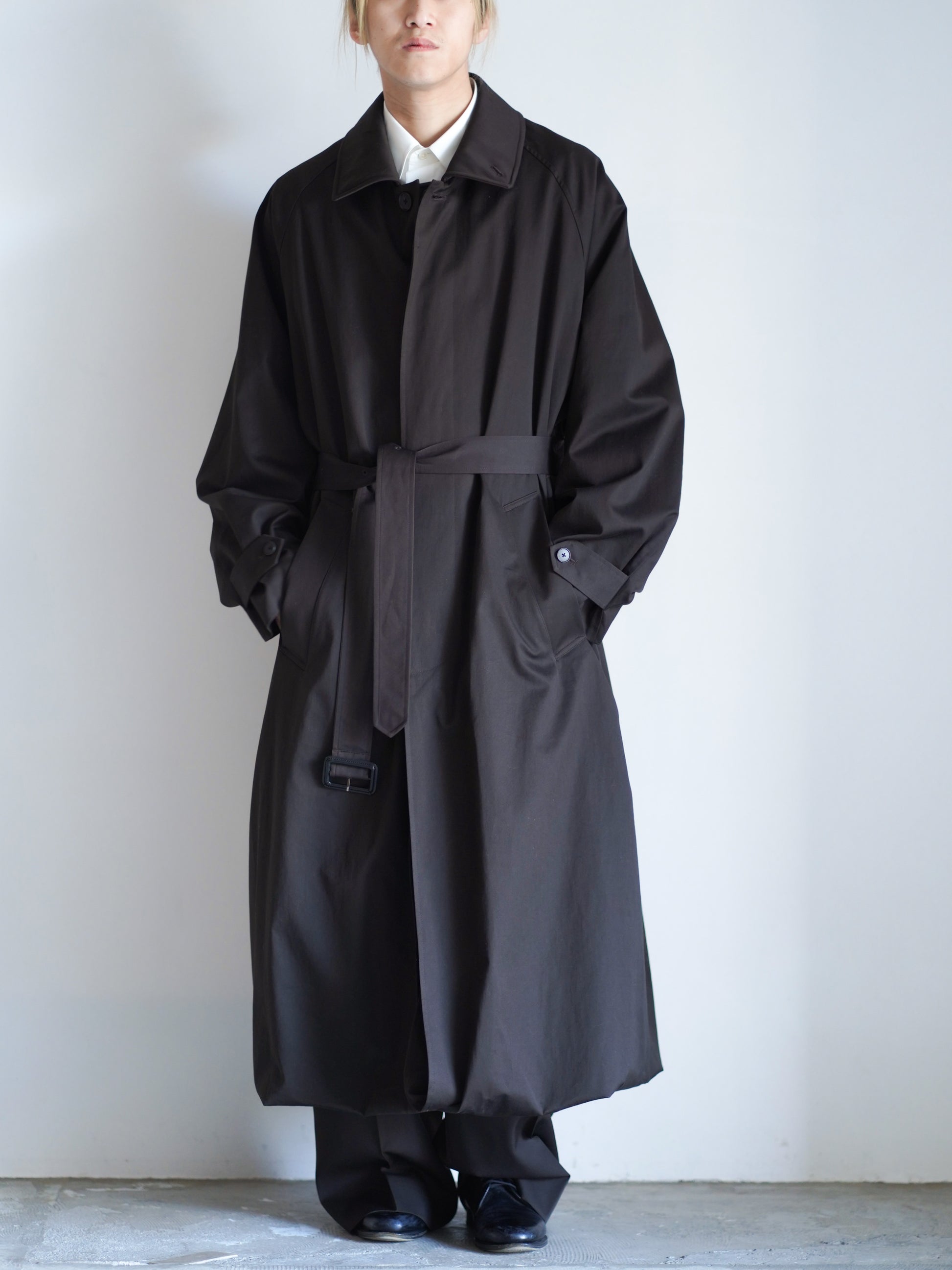 sssteinのOVERSIZED LAYERED COMBINATION COATのからーはDARK BROWNの襟をねかした際の全体の着用画像です。こちらは通販で購入可能です。