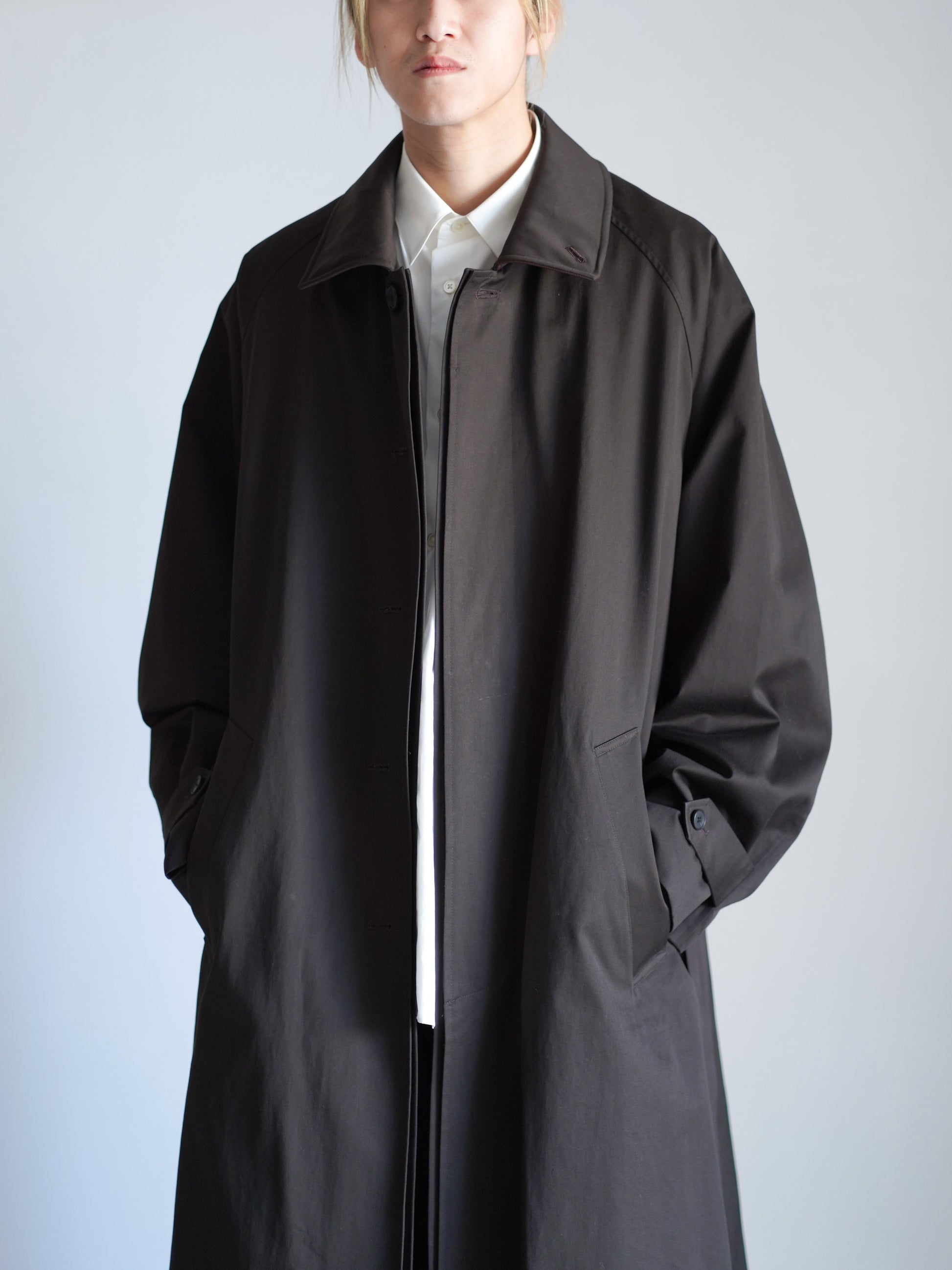 sssteinのOVERSIZED LAYERED COMBINATION COATのからーはDARK BROWNの上半身のアップの着用画像です。こちらは通販で購入可能です。