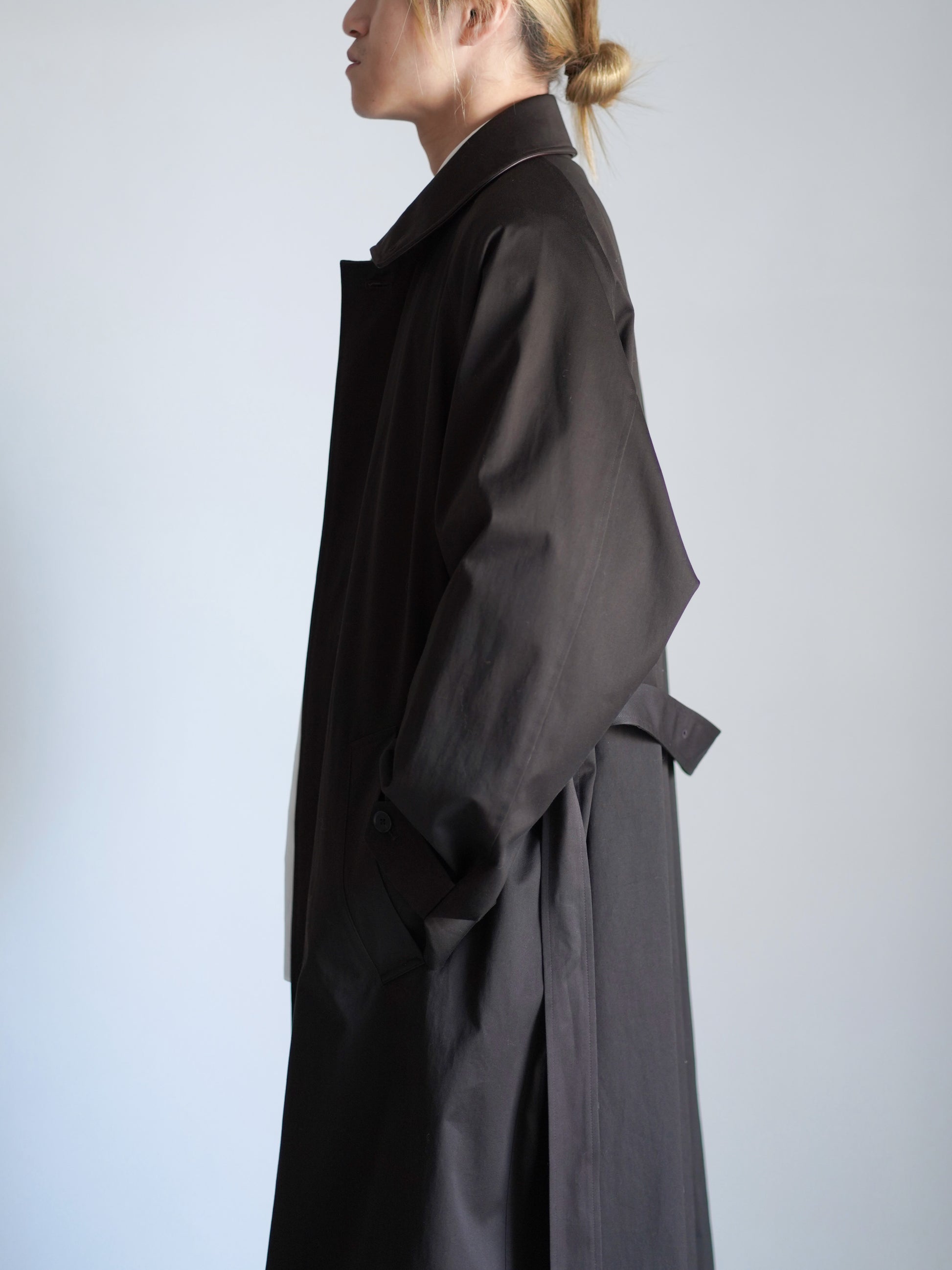 sssteinのOVERSIZED LAYERED COMBINATION COATのからーはDARK BROWNの上半身で横向きの着用画像です。こちらは通販で購入可能です。